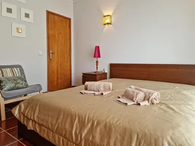 a bedroom with a bed with two towels on it at Falésia Beach Just 800 m (Apartment Surfal) in Roja- Pé