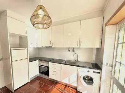 a kitchen with white cabinets and a sink and a dishwasher at Falésia Beach Just 800 m (Apartment Surfal) in Roja- Pé
