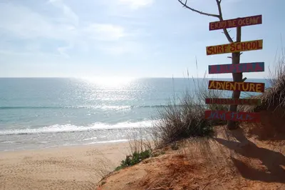 a sign on the side of a beach with the ocean at Falésia Beach Just 800 m (Apartment Surfal) in Roja- Pé