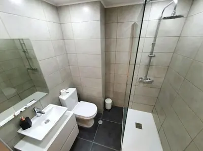a bathroom with a shower and a toilet and a sink at Old Town Apartment 5min to the beach in Albufeira