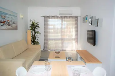 a living room with a couch and a table with wine glasses at Apartment MargemSul - Pool - Beach - Free Wifi - Air Con in Albufeira