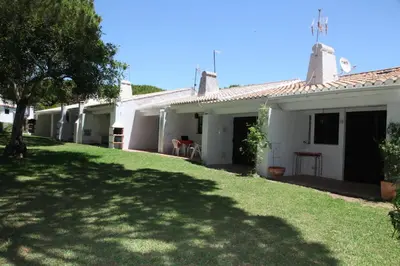 a white house with a green lawn in front of it at Acoteias Studio by be@home in Albufeira