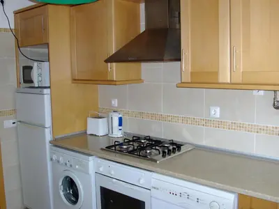 a kitchen with a stove top oven next to a dishwasher at Albufeira 2 bedroom apartment 5 min from Falesia beach and close to center I in Albufeira