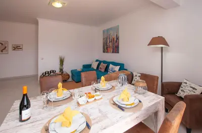 a living room with a table and a couch at Waves by OCvillas in Albufeira
