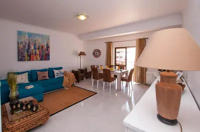 a living room with a blue couch and a table at Waves by OCvillas in Albufeira