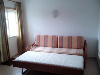 a couch sitting in a room with a window at Albufeira 1 bedroom apartment 5 min from Falesia beach and close to center D in Albufeira