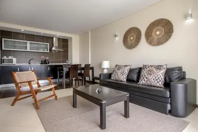 a lobby with couches and tables and windows at Areias Village Beach Suite Hotel in Albufeira
