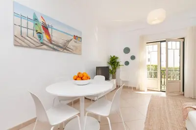 a white dining room with a white table and chairs at Apartamento Oura - BlueSea in Albufeira