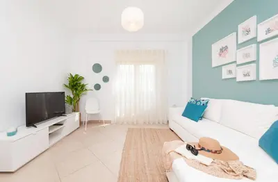a living room with a white couch and a tv at Apartamento Oura - BlueSea in Albufeira
