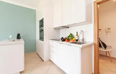 a display with two white vases on a shelf at Apartamento Oura - BlueSea in Albufeira