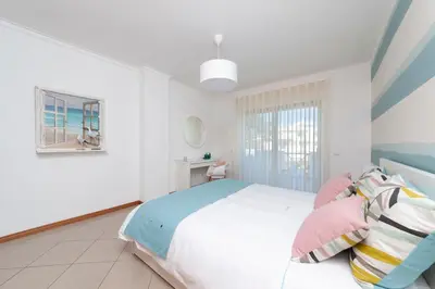 a white bedroom with a bed and a window at Santa Eulália Apartment Luxury - Blue Sea in Albufeira