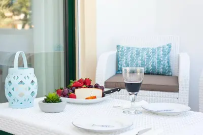 a table with a plate of food and a glass of wine at Santa Eulália Apartment Luxury - Blue Sea in Albufeira