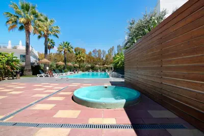 a swimming pool with a hot tub in front of a wall at PALM PARADISE SALGADOS in Albufeira