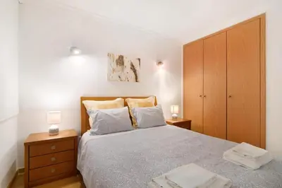 a bedroom with a bed with two night stands and two lamps at PALM PARADISE SALGADOS in Albufeira