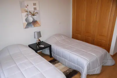 a bedroom with two beds and a table with a lamp at Apartamento Felicidade in Almancil