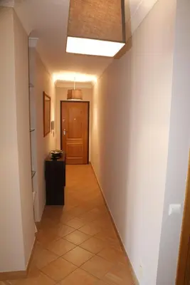 a hallway with a door and a tiled floor at Apartamento Felicidade in Almancil