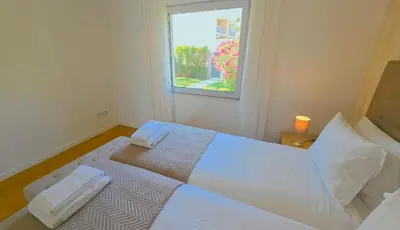 a white bed in a room with a window at Luxury villa & private heatable pool in Albufeira in Albufeira