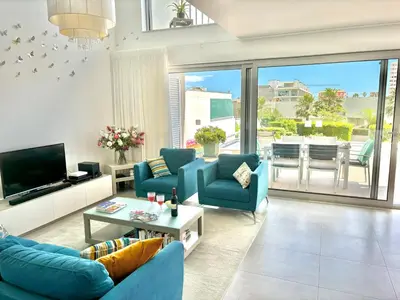 a living room with blue couches and a television at Luxury villa & private heatable pool in Albufeira in Albufeira