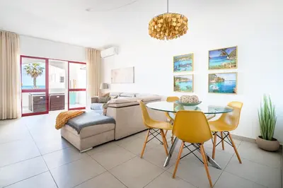 a street with palm trees and buildings on a beach at Apartamento Zacarias by Ferias com Sol in Quarteira