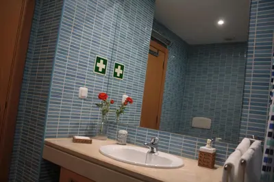 a blue tiled bathroom with a sink and a mirror at Apartamento com Piscina em Albufeira, Corcovada in Albufeira