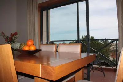a bowl of oranges on a wooden table with a window at Apartamento com Piscina em Albufeira, Corcovada in Albufeira