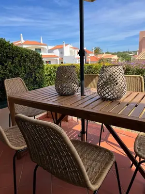a wooden table with chairs and an umbrella on a patio at Old Village Design 3 Bedroom Townhouse in Vilamoura