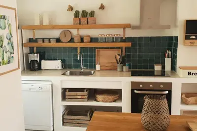 a kitchen with a sink and green tiles on the wall at Old Village Design 3 Bedroom Townhouse in Vilamoura