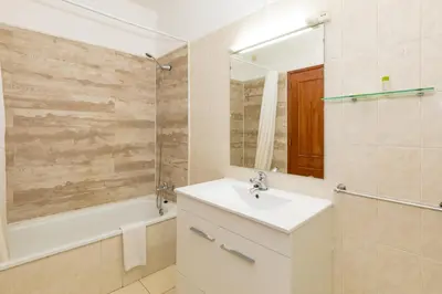 a bathroom with a sink and a tub and a mirror at Natura Algarve Club in Albufeira
