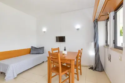 a dining room with a table and a bed at Natura Algarve Club in Albufeira