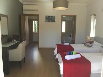 a hotel room with two beds and a desk and a room with two beds at Casa da Colina in Loulé