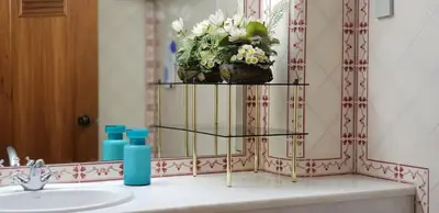 a bathroom with a sink and a shelf with flowers on it at Varandas do Mar by Sunny Deluxe in Albufeira