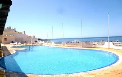a large swimming pool with the ocean in the background at Varandas do Mar by Sunny Deluxe in Albufeira