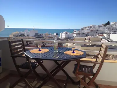 a table with two wine glasses on a balcony at Varandas do Mar by Sunny Deluxe in Albufeira
