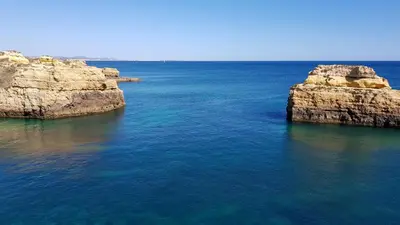 an aerial view of the ocean with two large rocks at Magnific Studio with a cozy garden, 5 minutes to the beach in Albufeira