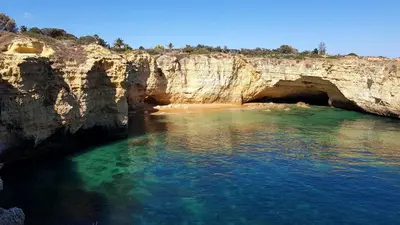 a cave in the ocean with a sandy beach at Magnific Studio with a cozy garden, 5 minutes to the beach in Albufeira