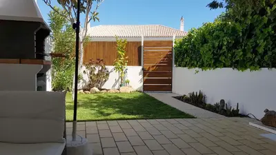 a backyard with a fence and a yard with a driveway at Magnific Studio with a cozy garden, 5 minutes to the beach in Albufeira