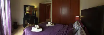 a bedroom with a purple bed with towels on it at Apt 2 Quartos, BBQ, AC, Terraço, Prestige For Home in Quarteira