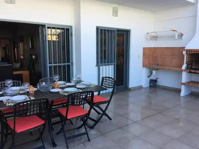 a dining room with a black table and red chairs at Apt 2 Quartos, BBQ, AC, Terraço, Prestige For Home in Quarteira