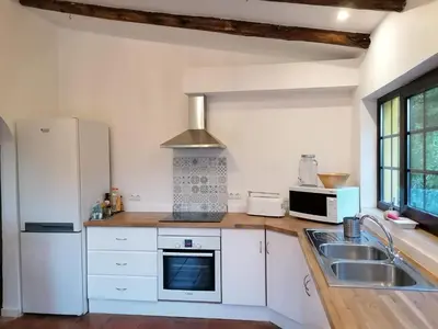 a kitchen with white cabinets and a sink and a stove at La Quinta casa com piscina privada in Loulé