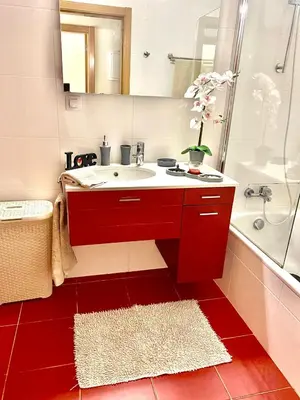 a bathroom with a red sink and a shower at Condomínio Olhos D'água T1 - Praia, sol e felicidade in Olhos de Água