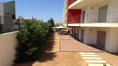 a christmas tree on a sidewalk next to a building at Condomínio Olhos D'água T1 - Praia, sol e felicidade in Olhos de Água
