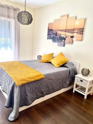 a bedroom with a bed with yellow pillows at Condomínio Olhos D'água T1 - Praia, sol e felicidade in Olhos de Água