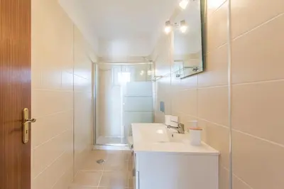 a white bathroom with a sink and a mirror at Villa Rita in Silves