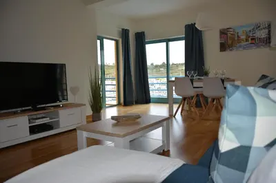 a living room with a couch and a tv and a table at Stunning Apartment with Marina Views in Albufeira