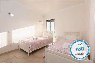 a bedroom with two beds and a sign that says clean and sale at Moradia Ricardo - Praia da Gale in Albufeira