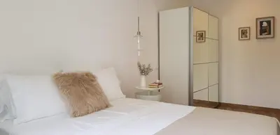 a white bed with a furry pillow on it at Casa da Mouraria in Faro