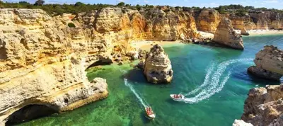 a group of boats in the water near cliffs at 241 Oliveiras Terraces in Albufeira