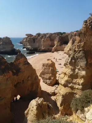 a group of people on a beach near the ocean at Apartamentos Sao Rafael, 80b in Albufeira