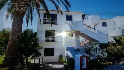 a white building with a palm tree in front of it at Apartamentos Sao Rafael, 80b in Albufeira