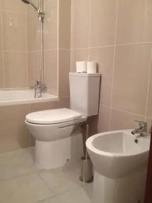 a bathroom with a white toilet and a sink at Solgarve in Quarteira